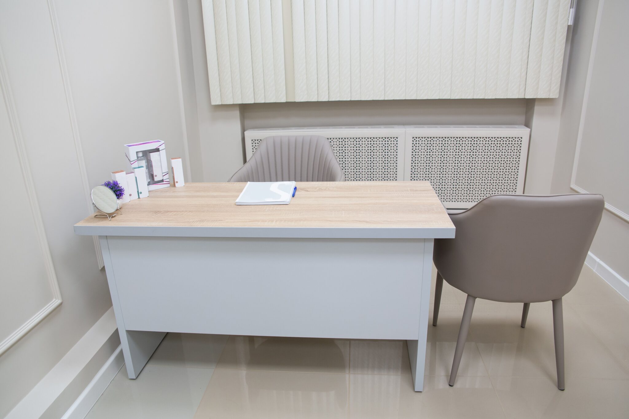 Clean and organized medical office desk with chairs and equipment, perfect for healthcare settings.